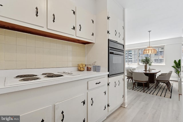 1900 John F Kennedy Blvd Unit 924, Philadelphia, PA 19103 - kitchen featuring oven, white cabinetry, light countertops, white electric stovetop, and decorative backsplash
