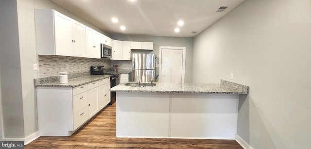 320 Third St, Fredericksburg, VA 22408 - kitchen with appliances with stainless steel finishes, a peninsula, light stone counters, decorative backsplash, and white cabinets