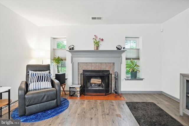 7100 Cipriano Springs Dr, Lanham, MD 20706 - living room with a tile fireplace, wood finished floors, plenty of natural light, and baseboards