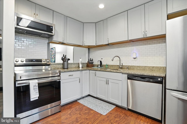 7100 Cipriano Springs Dr, Lanham, MD 20706 - kitchen featuring stainless steel appliances, a sink, dark wood-style flooring, light stone countertops, and tasteful backsplash