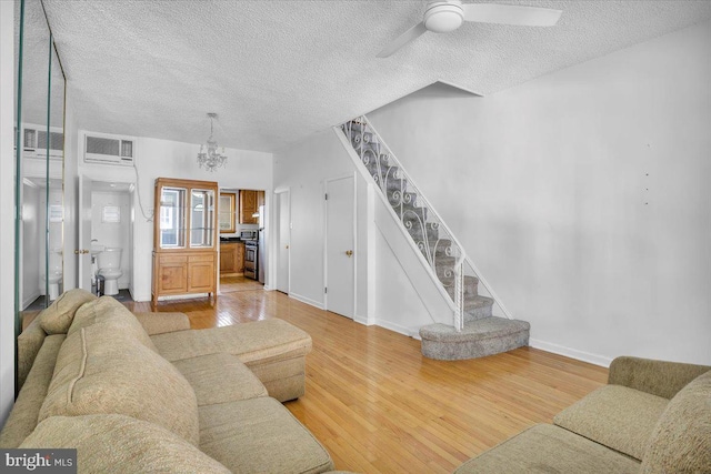 2637 S Bouvier St, Philadelphia, PA 19145 - living area featuring stairs, a textured ceiling, wood finished floors, ceiling fan, and a chandelier