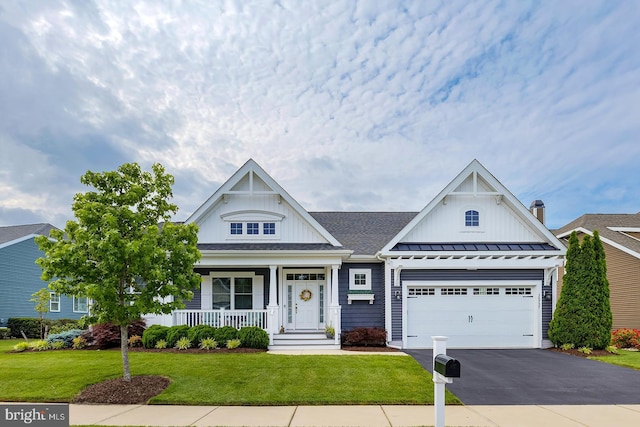 30957 Fowlers Path, Millsboro, DE 19966 - view of front of home featuring driveway, covered porch, a front lawn, a garage, and a standing seam roof