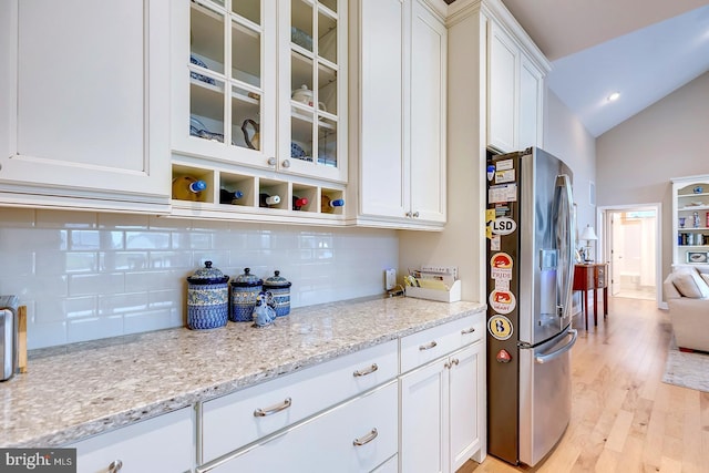 30957 Fowlers Path, Millsboro, DE 19966 - kitchen featuring stainless steel refrigerator with ice dispenser, light wood-style floors, white cabinets, tasteful backsplash, and lofted ceiling