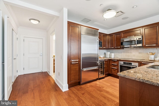 50 S 16th St Unit 4507, Philadelphia, PA 19102 - kitchen with stainless steel appliances, beverage cooler, light stone countertops, light wood finished floors, and backsplash