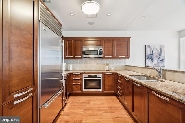 50 S 16th St Unit 4507, Philadelphia, PA 19102 - kitchen featuring stainless steel appliances, light wood-type flooring, light stone countertops, tasteful backsplash, and recessed lighting