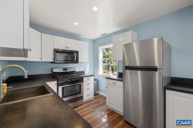 1007 Saint Charles Ave, Charlottesville, VA 22901 - kitchen with appliances with stainless steel finishes, a sink, dark countertops, white cabinets, and recessed lighting