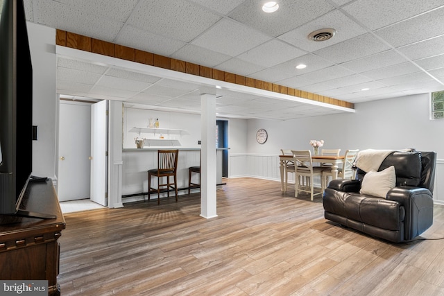 108 Partridge Way, Landenberg, PA 19350 - living area featuring a drop ceiling, wood finished floors, a bar, and a wainscoted wall