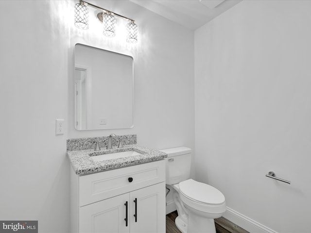 1026 Indian Dr, Auburn, PA 17922 - half bath featuring vanity, wood finished floors, toilet, and baseboards