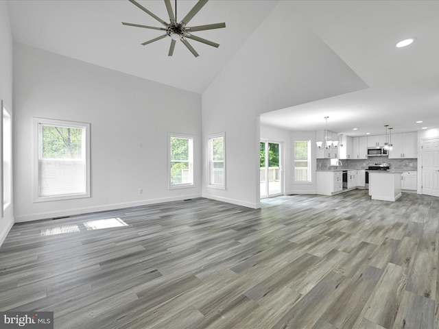 1026 Indian Dr, Auburn, PA 17922 - unfurnished living room with recessed lighting, a chandelier, a ceiling fan, light wood finished floors, and high vaulted ceiling