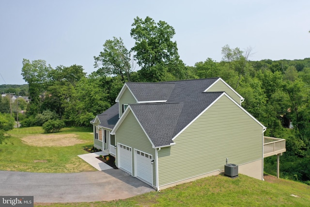 1026 Indian Dr, Auburn, PA 17922 - view of side of home with roof with shingles, a yard, central AC unit, asphalt driveway, and a garage