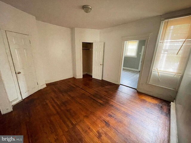 6065 Chester Ave, Philadelphia, PA 19142 - unfurnished bedroom with dark wood-type flooring, a closet, and baseboards