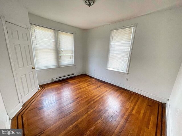6065 Chester Ave, Philadelphia, PA 19142 - unfurnished room with a baseboard radiator, plenty of natural light, wood finished floors, and baseboards