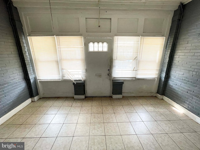 6065 Chester Ave, Philadelphia, PA 19142 - foyer featuring light tile patterned floors, brick wall, and baseboards