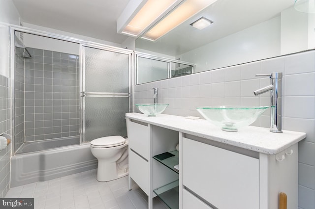 4201 Cathedral Ave NW Unit 910W, Washington, DC 20016 - bathroom featuring vanity, tile walls, tile patterned floors, and bath / shower combo with glass door