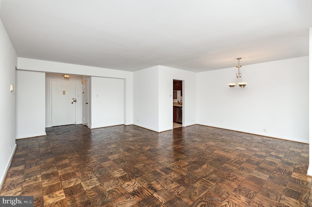 4201 Cathedral Ave NW Unit 910W, Washington, DC 20016 - unfurnished living room featuring baseboards and a chandelier