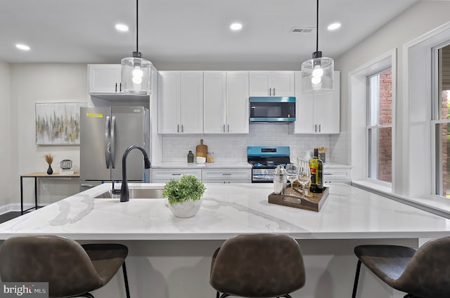 3121 Gwynns Falls Pkwy, Baltimore, MD 21216 - kitchen featuring appliances with stainless steel finishes, white cabinets, tasteful backsplash, hanging light fixtures, and recessed lighting