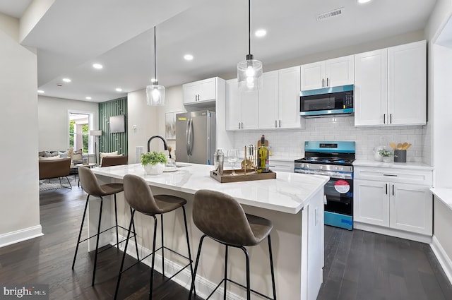 3121 Gwynns Falls Pkwy, Baltimore, MD 21216 - kitchen featuring stainless steel appliances, white cabinets, dark wood-type flooring, and recessed lighting