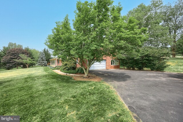 3314 Skyview Dr, Glenville, PA 17329 - view of property hidden behind natural elements featuring asphalt driveway, brick siding, a front yard, and an attached garage