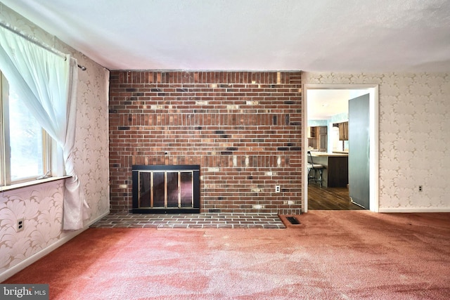 3314 Skyview Dr, Glenville, PA 17329 - unfurnished living room with wallpapered walls, carpet flooring, a brick fireplace, and baseboards