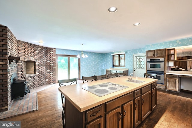 3314 Skyview Dr, Glenville, PA 17329 - kitchen featuring wallpapered walls, electric cooktop, stainless steel double oven, a sink, and a wood stove