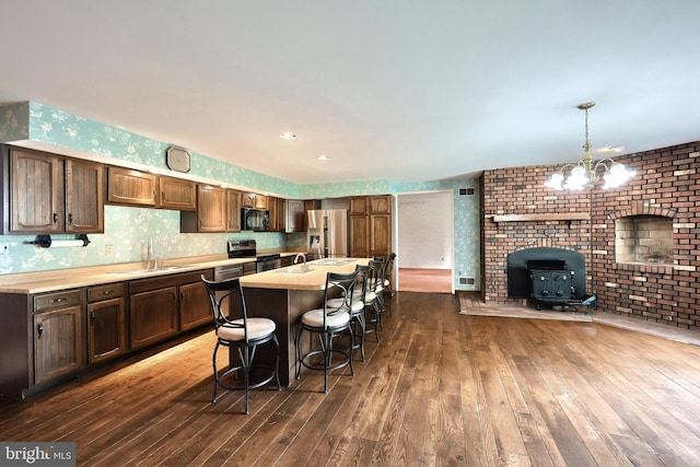 3314 Skyview Dr, Glenville, PA 17329 - kitchen featuring stainless steel appliances, dark wood-style floors, light countertops, a sink, and a kitchen breakfast bar
