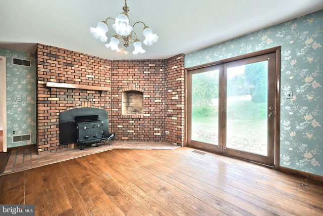 3314 Skyview Dr, Glenville, PA 17329 - unfurnished living room with wallpapered walls, hardwood / wood-style floors, a wood stove, and a chandelier