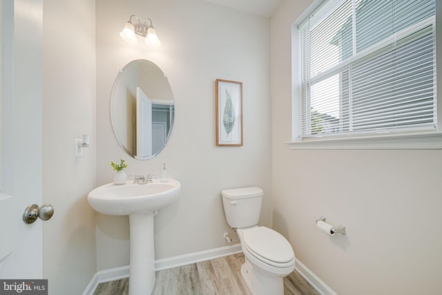 9563 Jefferson St, Manassas, VA 20110 - half bath with wood finished floors, toilet, baseboards, and a sink