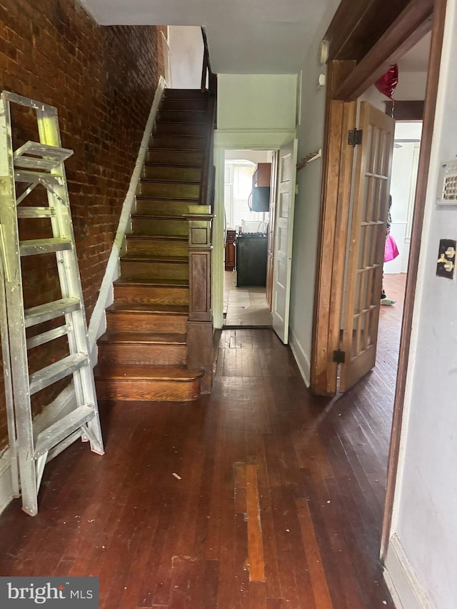 236 Randolph Pl NE, Washington, DC 20002 - staircase with hardwood / wood-style floors and brick wall