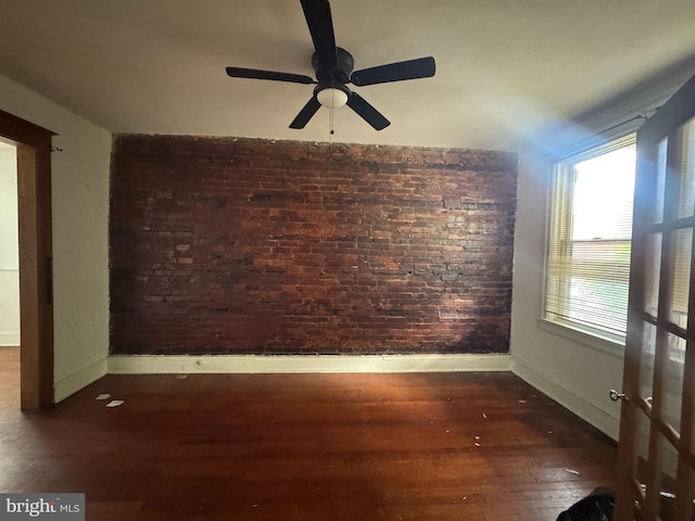 236 Randolph Pl NE, Washington, DC 20002 - spare room featuring brick wall, baseboards, wood-type flooring, and a ceiling fan