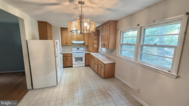 21305 Three Notch Rd, Lexington Park, MD 20653 - kitchen with white appliances, baseboards, a chandelier, light countertops, and brown cabinets