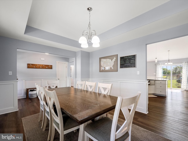 215 Naples Way, Charles Town, WV 25414 - dining space with a chandelier, dark wood-style flooring, a wainscoted wall, a raised ceiling, and a decorative wall