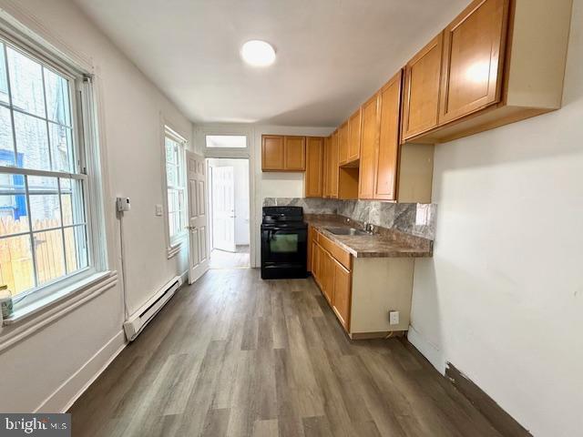1343 Muhlenberg St, Reading, PA 19602 - kitchen with range, a baseboard radiator, a sink, wood finished floors, and healthy amount of natural light