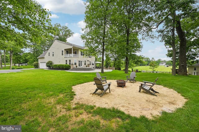 2425 Ellies Way W, Friendship, MD 21794 - rear view of house with an outdoor fire pit, a balcony, a garage, and a yard