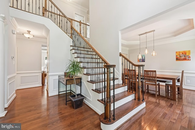 2425 Ellies Way W, Friendship, MD 21794 - staircase with wood finished floors, crown molding, a decorative wall, and wainscoting