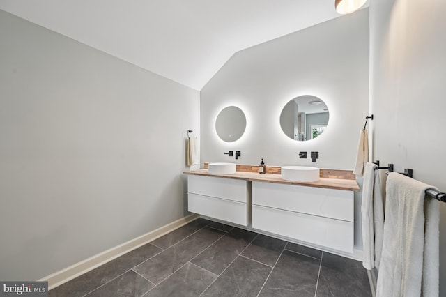 2425 Ellies Way W, Friendship, MD 21794 - bathroom featuring double vanity, lofted ceiling, and baseboards