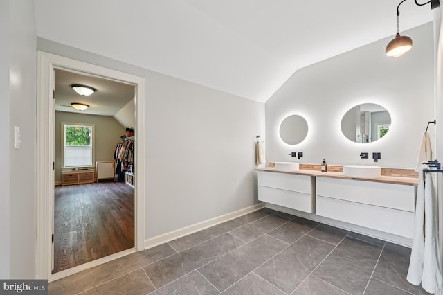 2425 Ellies Way W, Friendship, MD 21794 - bathroom featuring vaulted ceiling, double vanity, baseboards, and a spacious closet
