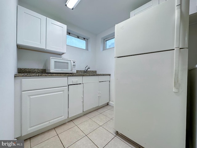 8432 Ravenswood Rd, New Carrollton, MD 20784 - kitchen featuring white appliances, white cabinets, light tile patterned flooring, and dark stone counters