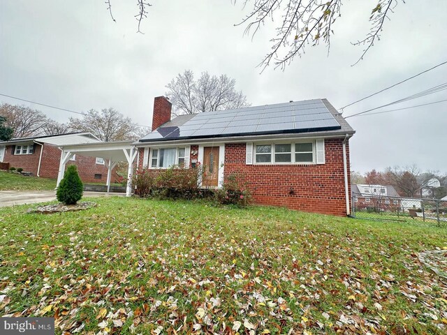 8432 Ravenswood Rd, New Carrollton, MD 20784 - bungalow with brick siding, a chimney, roof mounted solar panels, an attached carport, and concrete driveway
