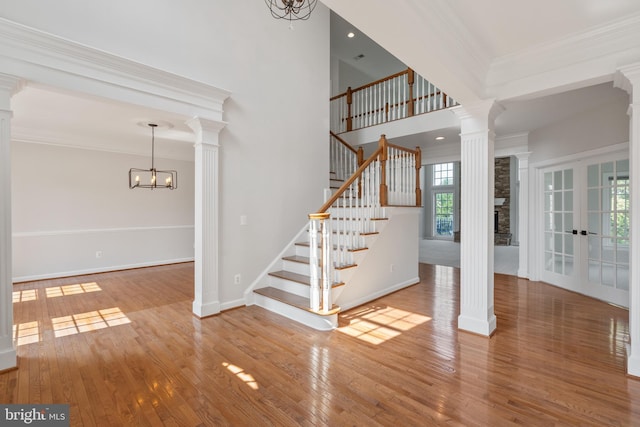 6513 Debhill Ln, Gainesville, VA 20155 - stairs with decorative columns, a chandelier, wood-type flooring, and crown molding