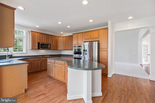 6513 Debhill Ln, Gainesville, VA 20155 - kitchen with appliances with stainless steel finishes, a sink, dark countertops, a center island, and light wood finished floors