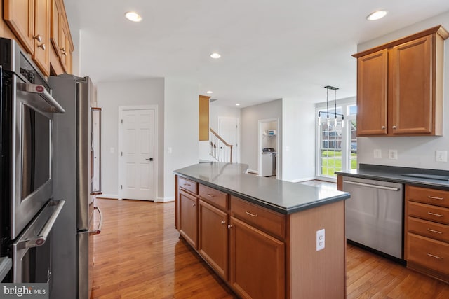 6513 Debhill Ln, Gainesville, VA 20155 - kitchen featuring appliances with stainless steel finishes, dark countertops, light wood-type flooring, recessed lighting, and brown cabinets