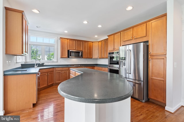 6513 Debhill Ln, Gainesville, VA 20155 - kitchen with appliances with stainless steel finishes, dark countertops, a center island, light wood-style flooring, and recessed lighting