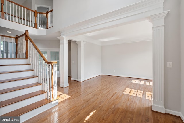 6513 Debhill Ln, Gainesville, VA 20155 - unfurnished living room featuring ornate columns, baseboards, wood finished floors, stairs, and ornamental molding