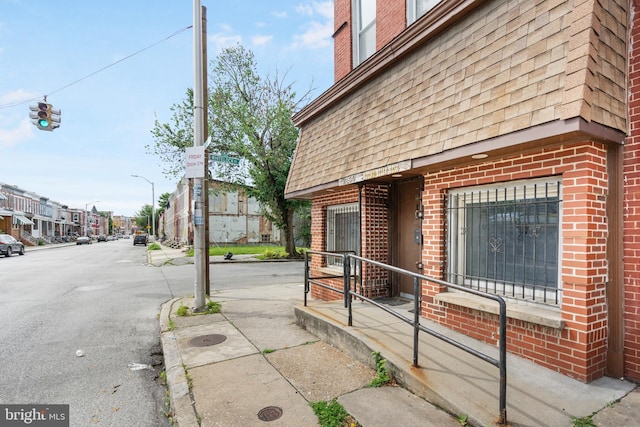 2400 Druid Hill Ave, Baltimore, MD 21217 - view of side of home with brick siding, a shingled roof, and mansard roof