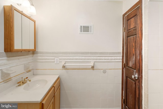 2400 Druid Hill Ave, Baltimore, MD 21217 - bathroom with vanity, tile walls, and a wainscoted wall