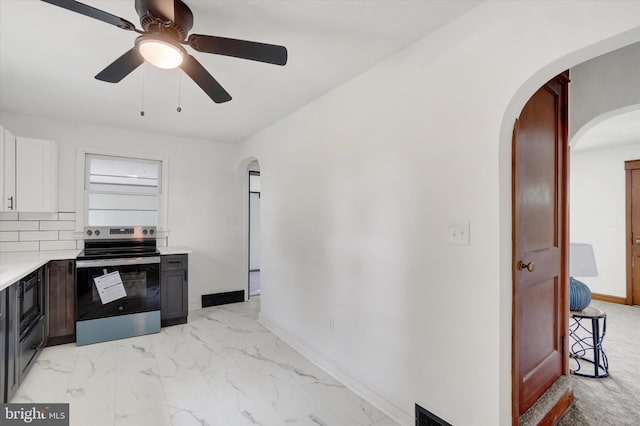 3330 E Prospect Rd, York, PA 17402 - kitchen featuring stainless steel range with electric stovetop, arched walkways, light countertops, ceiling fan, and light marble finish flooring