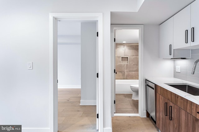 845 19th St NE Unit 4, Washington, DC 20002 - kitchen featuring a sink, dishwasher, light wood finished floors, and white cabinetry