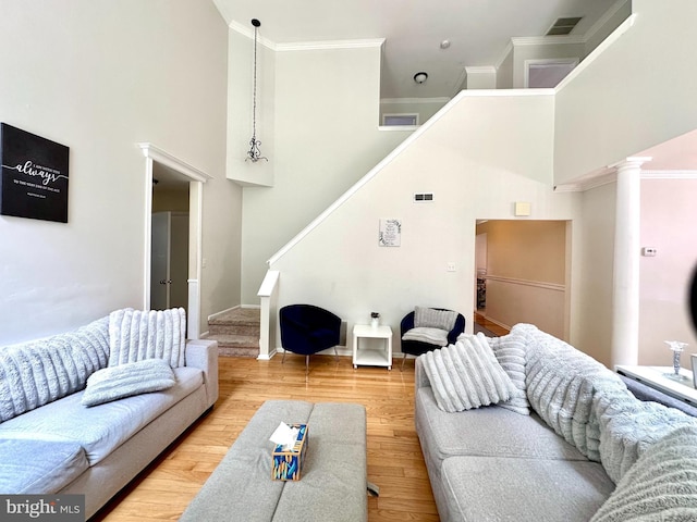 211 Franklin Ave, Berlin, NJ 08009 - living room featuring a high ceiling, stairs, wood finished floors, crown molding, and decorative columns