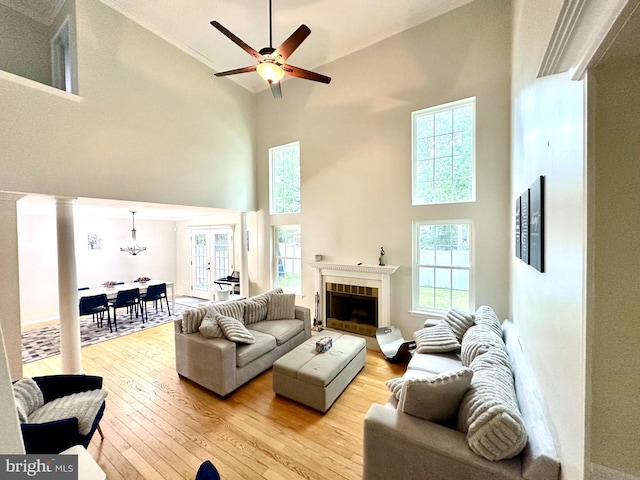 211 Franklin Ave, Berlin, NJ 08009 - living room with a towering ceiling, light wood-style flooring, a tile fireplace, ceiling fan, and a chandelier