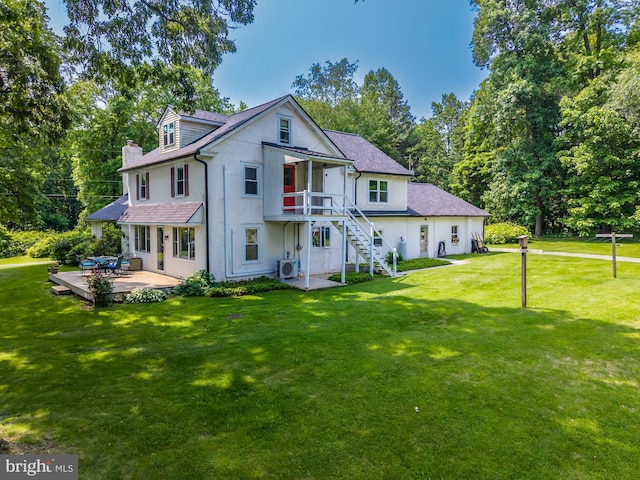 1034-1040 Twin County Rd, Honey Brook, PA 19344 - rear view of property featuring stairway, a patio area, a lawn, and stucco siding